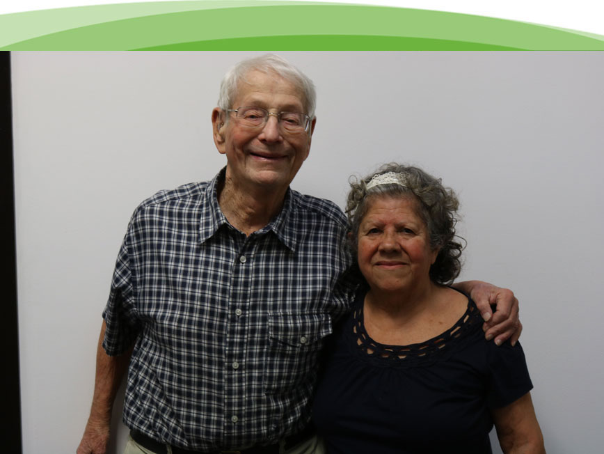 Un hombre y una mujer mayores abrazándose y sonriendo porque recibieron ayuda de la Sociedad Auditiva de Chicago.